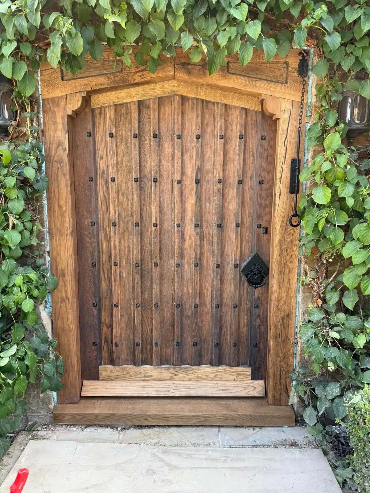 Restored period studded oak door rehung in a stone reveal